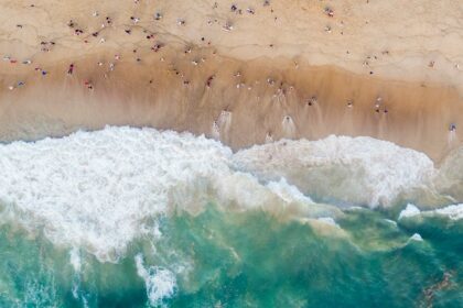 A bird’s eye view of the turquoise blue waters meeting the golden pristine sands.