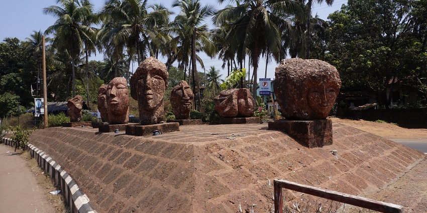 Snapshot of the stone statue and the lush palm trees surrounding the Calangute