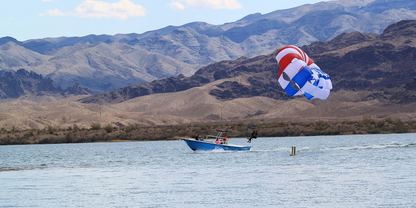 A breathtaking view of a water body with rocky hills and mountains in the background.