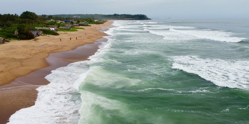 A view of the Candolim Beach featuring shimmering blue waters and golden sands.