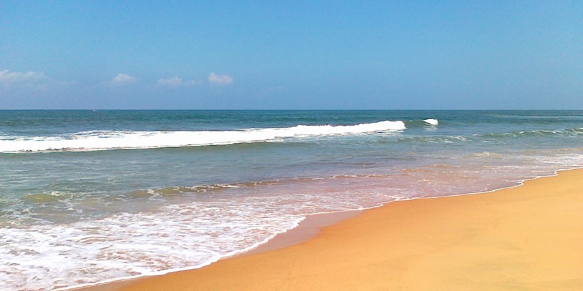 Peaceful Candolim Beach with calm waves, sunbeds, and a relaxing coastal atmosphere.