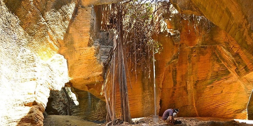 Stunning view of Naida Caves with sunlight illuminating the rock formations and water.