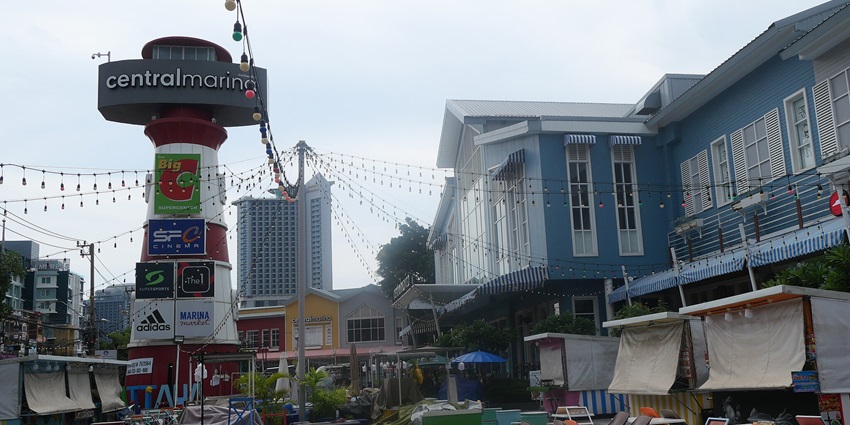 Central Marina board sign behind an open restaurant with chairs for shopping in Pattaya.