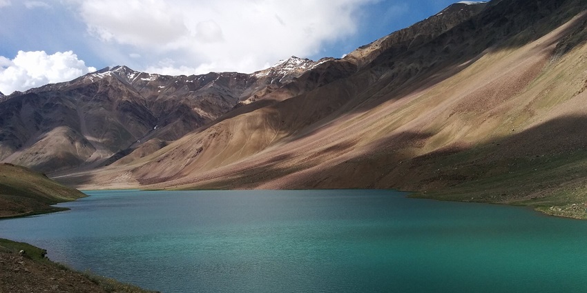 Chandratal Lake, reflecting snow-capped peaks, is a stunning spot in Spiti Valley. A must-visit place in Spiti Valley in May