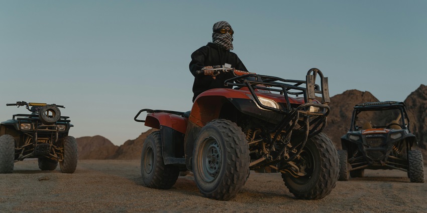Man speeding on ATV across the sand, a popular activity at Chandravati Adventure Park.