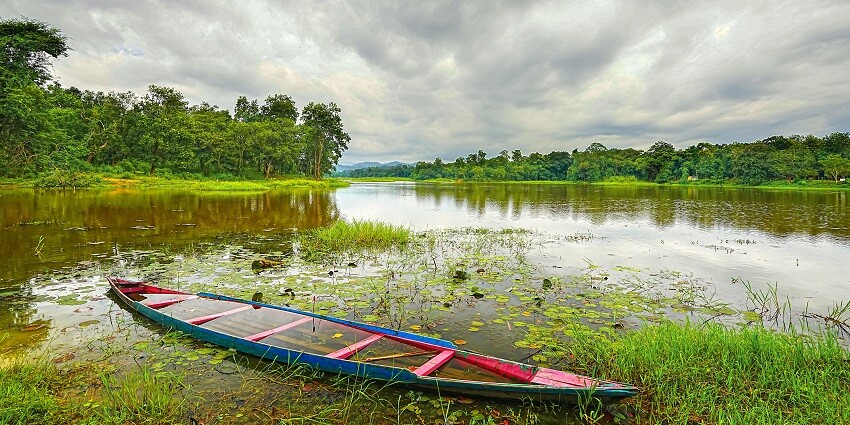 A glimpse of serene waters, green grasses decked with colourful boats at Chandubi Lake.