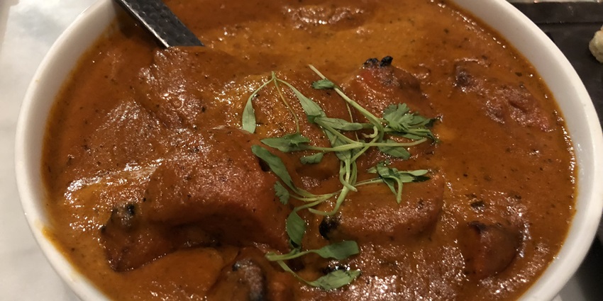 Butter chicken curry garnished with coriander, one of the best non veg dished in Delhi