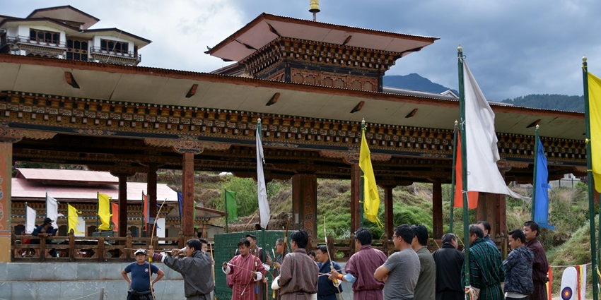 Traditional archery ground with Bhutanese flags and spectators at Changlimithang, Thimphu.