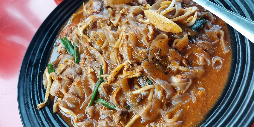 Char Kuey Teow, a stir-fried flat noodle dish with seafood - one of the best foods in Singapore.