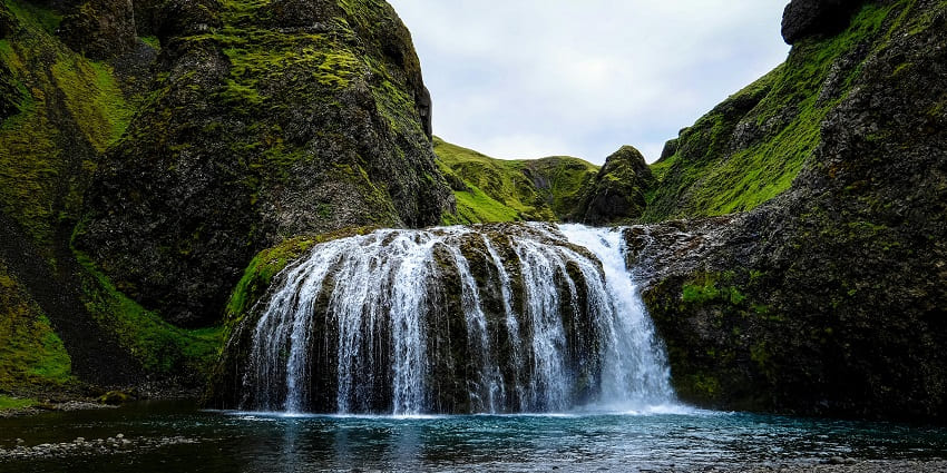 Breathtaking landscape featuring a cascading waterfall surrounded by lush greenery