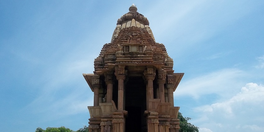 Front view of Chaturbhuj Temple featuring intricate carvings and a prominent, towering spire.