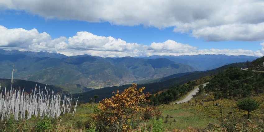 Prayer-flag-lined mountain pass with panoramic Himalayan views at Chele La, Bhutan.
