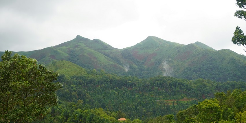 Breathtaking vistas of Chikmagalur, including lush green mountains during the day.