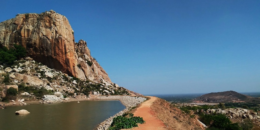 A mesmerising view of rocky cliffs, serene waters, and sandy terrains in Chintamani.