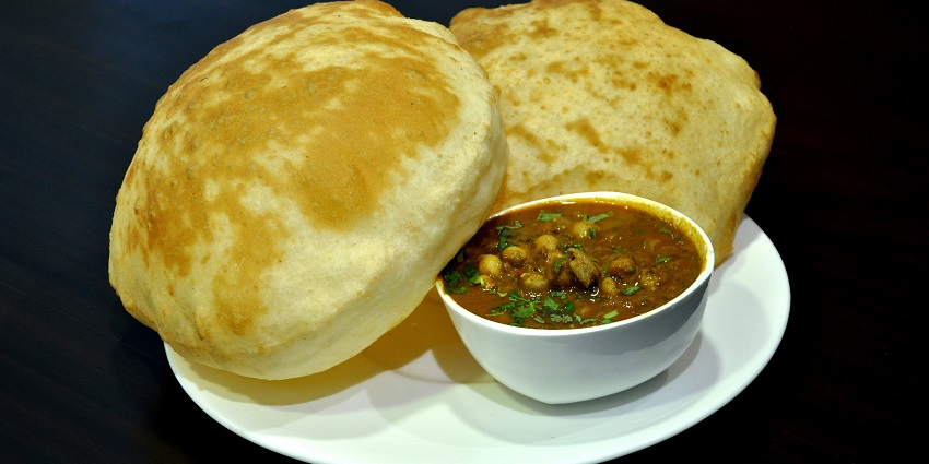 Image of deletable chole bhature served on a white plate - one of the best food in Delhi