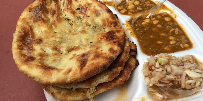 Delicious Choor choor naan served with chole curry and onions