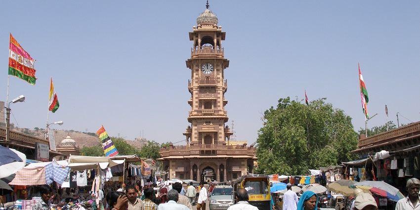 Famous Clock Tower near Umaid Bhawan Museum, with a bustling marketplace surrounding it.
