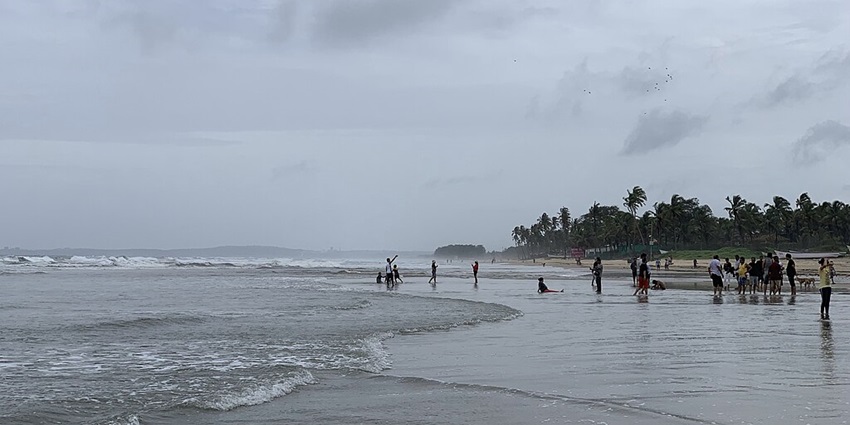 A picture taken at a beach with tiny waves approaching the shore