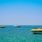 Picturesque view of boat parking at Colva beach under clear blue - Colva beach water sports