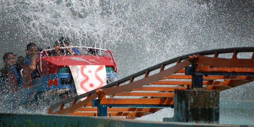 A glimpse of people emerging through splashing water as they enjoy a thrilling ride.