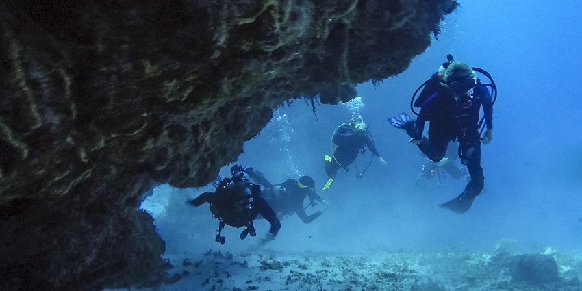 Image of Scuba Divers swimming through a coral cave - diving in Baga beach at Goa