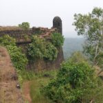 Walls of the Cojuem fort covered with moss and surrounded by lush shrubs