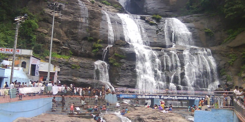 A picture of a waterfall in Kerala with tourists enjoying