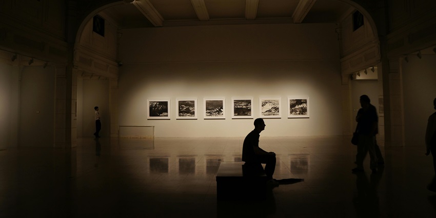 Peaceful silhouette of a person relaxing on a bench, enjoying the museum's ambience.