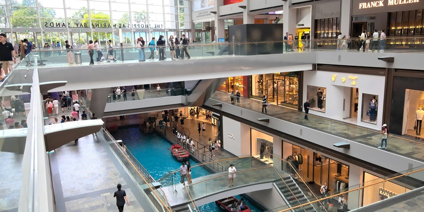 People walking inside the mall exploring the high end luxury brands like Louis Vuitton, etc.