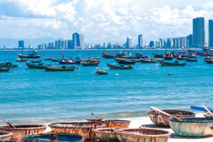 Traditional Vietnamese coracles on the pristine white sands with gentle blue waves.