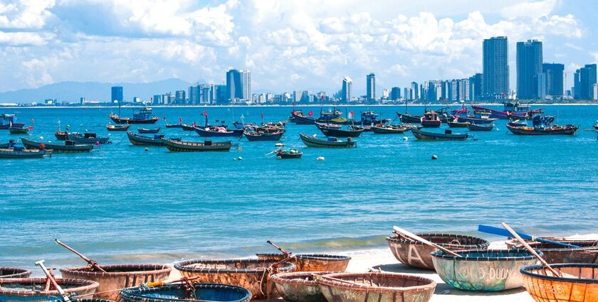 Traditional Vietnamese coracles on the pristine white sands with gentle blue waves.