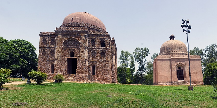 A picture of two identical tombs next to each other, surrounded by lush greenery