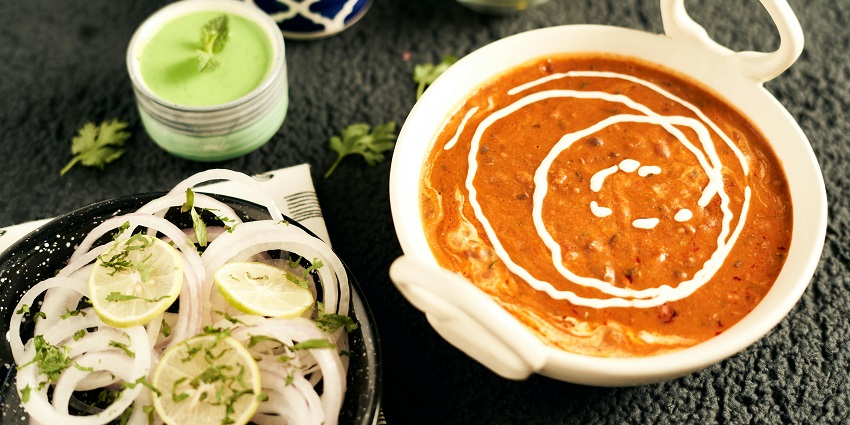 A bowl of creamy Dal Makhani garnished with fresh cilantro and a swirl of cream.