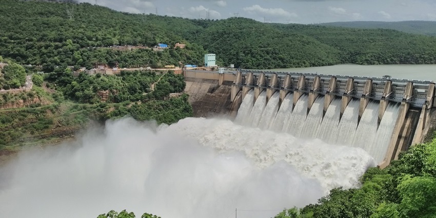Srisailam Dam, a massive structure, showcases stunning views of water and surrounding hills.