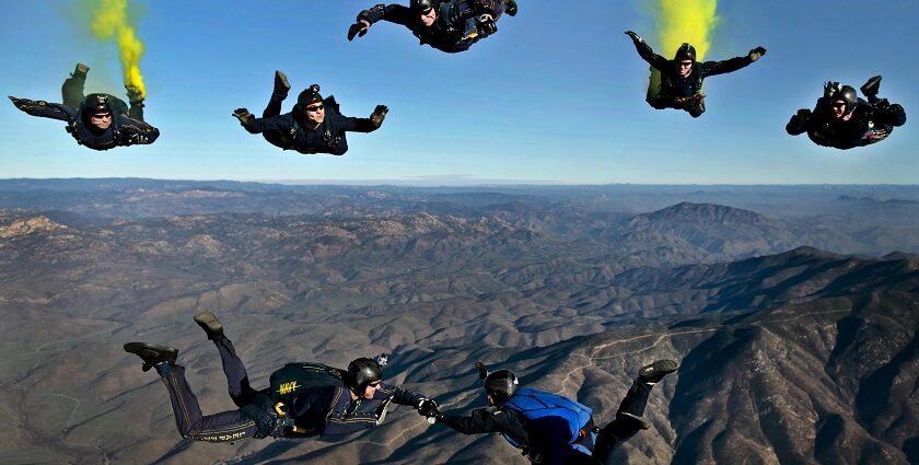 A mesmerising view of a group of people enjoying skydiving in clear blue skies in the day.