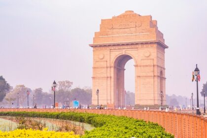 A breathtaking view of a brown monument surrounded by lush greenery during the day.