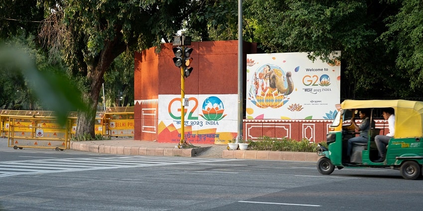 Image of a man driving a cart down a bustling street, surrounded by vibrant city life.