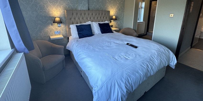Elegant deluxe suite bedroom featuring a plush bed, stylish decor, and warm lighting.