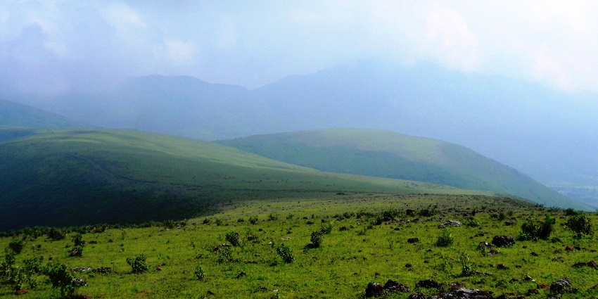 Deomali Peak in Odisha, with its lush green slopes, rocky outcrops, and a clear blue sky