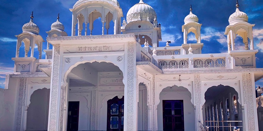 A picture of a historical monument in Hoshiarpur built with marble under a clear blue sky