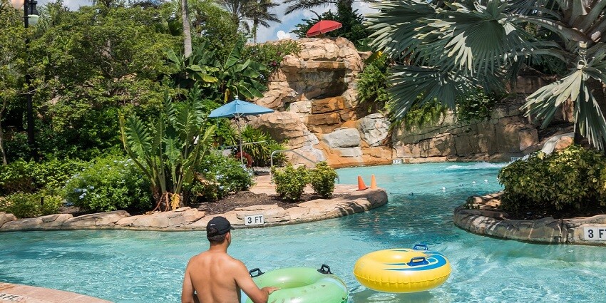 Children having fun on water slides splashing into the pool at Desert Aqua Water Park