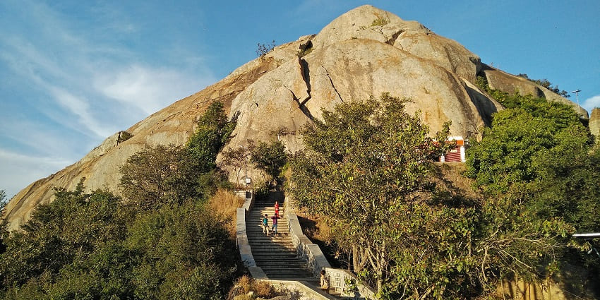 A serene glimpse of the towering Devarayanadurga surrounded by lush greenery.