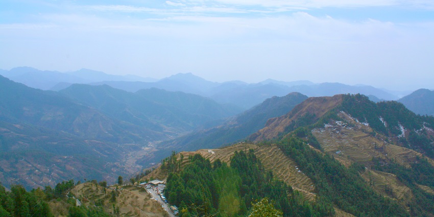 A scenic view of Dhanaulti, Uttarakhand, one of the hill stations near Gurugram, showcasing lush greenery and distant hills.