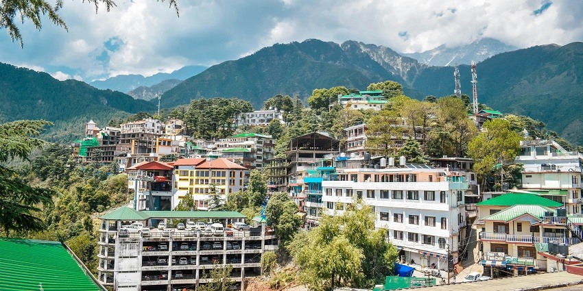 Image of McleodGanj in Dharamshala surrounded by lush green mountains and builds on the of the hills