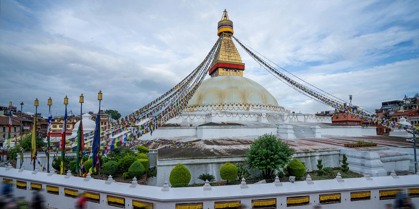 A mesmerising view of the pristine white Dhauli Shanti Stupa adorned with vibrant hues.