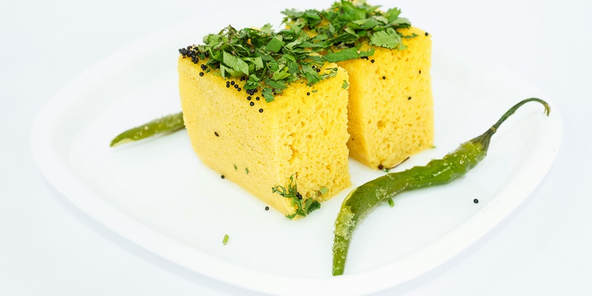Here’s a plate of soft, spongy Dhokla slices garnished with mustard seeds and coriander.