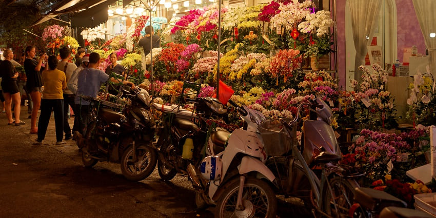 Bustling market in Hanoi's Old Quarter, with vendors selling fresh produce, vibrant fruits and vegetables on display