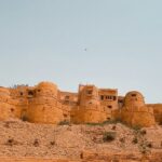 The Jaisalmer Fort standing tall amidst the Thar Desert in Rajasthan under clear blue sky