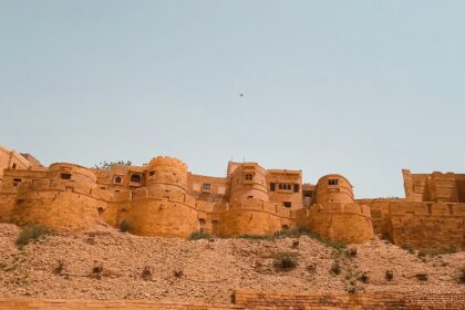 The Jaisalmer Fort standing tall amidst the Thar Desert in Rajasthan under clear blue sky