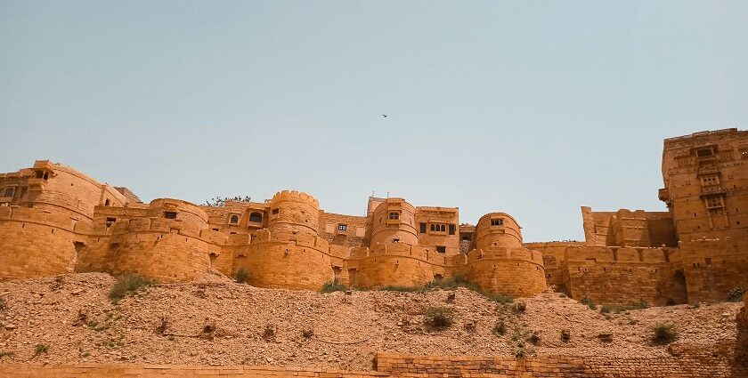 The Jaisalmer Fort standing tall amidst the Thar Desert in Rajasthan under clear blue sky